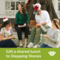 Four people sitting on a bench with a dog, wearing Santa hats, with text ' gift a shared lunch to Stepping Stones'